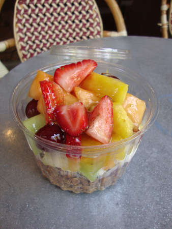 Serving of yogurt with fresh berries and granola glazed with honey at a San Franciscan Cafe in a transparent plastic container の写真素材