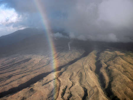 Rainbow hangs over west Maui modern windmills taken from an airplane windowの写真素材