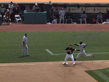Red Sox vs. Athletics: As Daric Barton reachs out as he grabs throw before Red Sox runner Bill Hall crosses first.  Taken on July 21, 2010 at the Coliseum in Oakland California.のeditorial素材