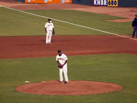 Mets vs. Giants:  Giants Santiago Casilla looks to the dugout while 1st baseman Pablo Sandoval blows bubble.  Taken July 17 2010 at the ATT Park San Francisco.のeditorial素材
