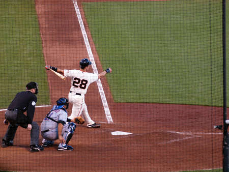 Mets vs. Giants: Giants Buster Posey swings through a pitch with catcher and umpire behind him.  Taken July 17 2010 at the ATT Park San Francisco.のeditorial素材