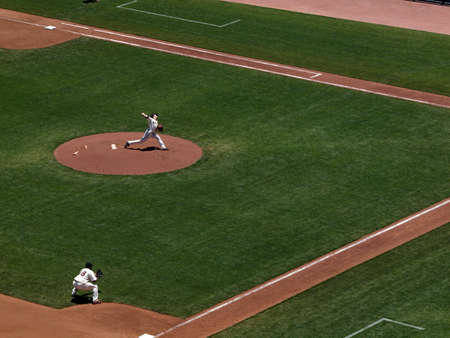 Giants Vs. Orioles: Giants two time Cy Young award winner Tim Lincecum in pitching motion with 3rd baseman squating in a fielding position during a day game.  June 16 2010 Att Park San Francisco Californiaのeditorial素材