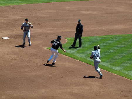 Blue Jays vs. Athletics: Athletics Conor Jackson stuck in a run down between Blue Jays 2nd baseman Aaron Hill and shortstop Yunel Escobar.  Taken on August 18 2010 at Coliseum in Oakland California.のeditorial素材