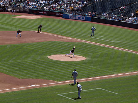 Blue Jays vs. Athletics: Athletics Athletics Gio Gonzalez throws pitch with Blue Jays Vernon Wells taking lead from 3rd base and 1st baseman Daric Barton ready for play.  Taken on August 18 2010 at Coliseum in Oakland California.のeditorial素材