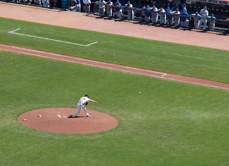Giants Vs. Cubs:Giants Brian Wilson throws pitch as cubs players watch standing in dugout.  August 12  2010 Att Park San Francisco Californiaのeditorial素材