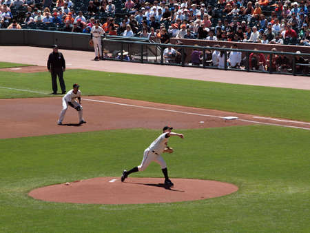 Giants Vs. Marlins: GGiants Matt Cain throws pitch as firstbaseman Travis Ishikawa stands ready.  August 12  2010 Att Park San Francisco Californiaのeditorial素材