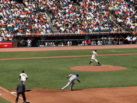Giants Vs. Cubs: Giants Matt Cain throws pitch as Cubs Starlin Castro runs to steal second as Giants dugout sits and watches.  August 12  2010 Att Park San Francisco Californiaのeditorial素材