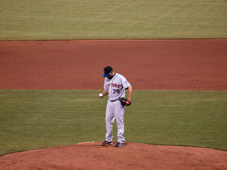 New York Mets vs. San Francisco Giants:  Mets Francisco Rodriguez stands on the mound looking down at the ball as he finds a grip on the ball.  Taken July 17 2010 at the ATT Park San Francisco.のeditorial素材
