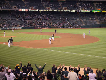 Blue Jays vs. Athletics: Athletics fans celebrate home run as Conor Jackson rounds the base after hitting homerun.  Taken on August 16 2010 at Coliseum in Oakland California.のeditorial素材