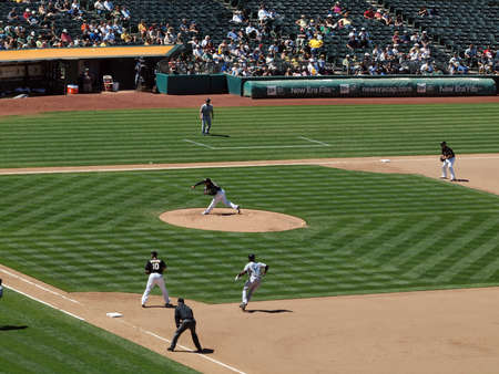 Blue Jays vs. Athletics: Athletics Henry Rodriguez throws pitch with Blue Jays Fred Lewis taking lead from first.  Taken on August 18 2010 at Coliseum in Oakland California.のeditorial素材