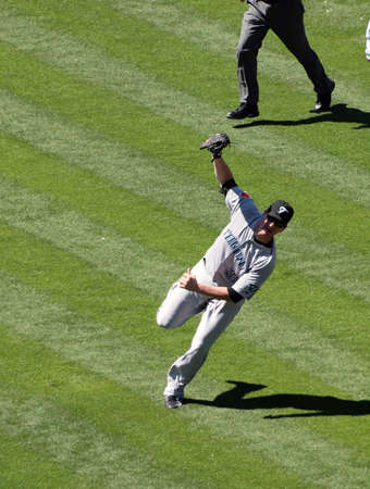 Blue Jays vs. Athletics: Blue Jays Lyle Overbay stands off balance after making a running catch for a fly ball.  Taken on August 18 2010 at Coliseum in Oakland California.のeditorial素材