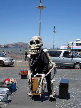 Skeleton man hangs out on fishermans wharf waiting for people wanting to take picture with him.  July 28, 2010 Fishermans Wharf, San Francisco California.のeditorial素材
