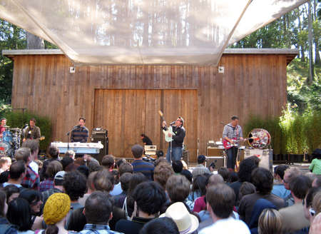 73rd Stern Grove Festival:  They Might Be Giants preforms during the opening act to a large crowd at outdoor concert.  Singer lifts guitar into the air.  August 22 2010 San Francisco CA.のeditorial素材