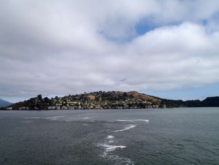 Salt and Fresh water mix in the bay with Marin in the distance and bird flying by.の写真素材