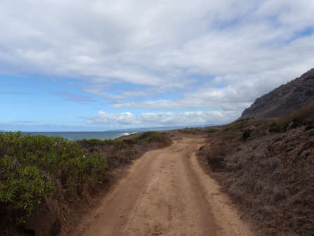 Dirt road rolls into the distance at Keana Point on Oahu, Hawaiiの写真素材