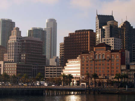 San Francisco Pier and Cityscape as rising sun reflects on buildings on a nice day の写真素材