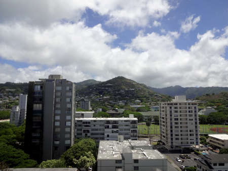 Tall building of Punahou with Tantalus Mountain in the distance and Koolau mountain range on Oahu, Hawaii.の写真素材