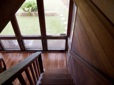 Wood Staircase leading downstairs to the dinning room with large windows featuring views of outsideの写真素材