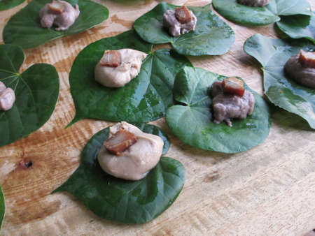 Poi on Taro Leafs top with a slice of Marin on a wood table                                の写真素材