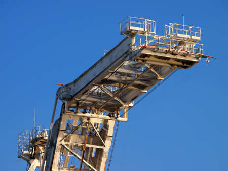 Lifting arm of Large crane with blue sky in Oakland Harbor, California.