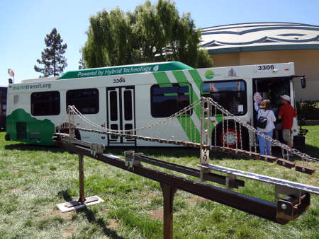 MARIN, CA - JUNE 30: People check out the Golden Gate Transit Hybrid bus on display behind model of Bridge at Marin County Fair. Top speed of 50 mph, and range of sunrise to sunset. Taken June 30, 2011 Marin, California.のeditorial素材