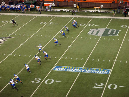 HONOLULU - OCTOBER 5: Line of SJSU players begin to run as they Kicks off the football, with kicker visibly kicking the ball at Aloha Stadium in Honolulu, Hawaii on October 5, 2013. のeditorial素材