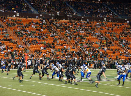 HONOLULU - OCTOBER 5: UH Quarterback Sean Schroeder sets to throw ball as other players scrabble for position at mid field at Aloha Stadium in Honolulu, Hawaii on October 5, 2013. のeditorial素材