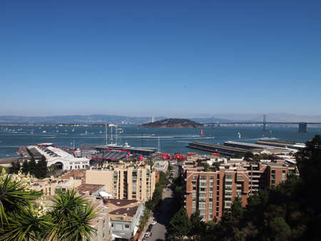 SAN FRANCISCO-SEPT 14:   Oracle Team USA and New Zealand Team race toward the Bay Bridge during the race of America's Cup with boats and helicopters following , and cityscape in the foreground seen from Telegraph Hill on Sept. 14, 2013 in San Francisco. Uのeditorial素材