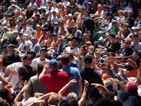 SAN FRANCISCO - AUGUST 12:  Excited fans reach with hands and gloves for foul ball hit in the stands...