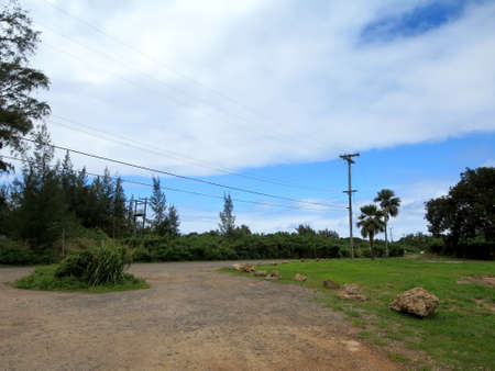 Dirt Road with a circle round, power poles, large coral rocks, and trees in Kahuku, Oahu.の写真素材