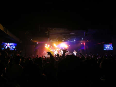 HONOLULU, HI - MARCH 30: Jurassic 5 raps on stage as fansin crowd throw hands in air, Lights at...