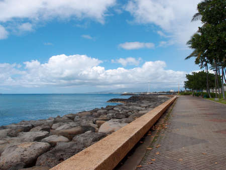 Path along Sea Wall with plants and palm tree lining the path at Kakaako Beach Park, Honolulu, Hawaii.の写真素材
