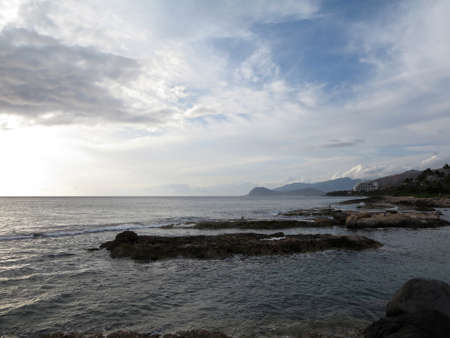 Rocky shore rock outcroppings helping to make lagoon at Ko Olina with hotels in the distance on Oahu, Hawaii. With A view of the leeward coast and the Waianae Mountain Range. の写真素材