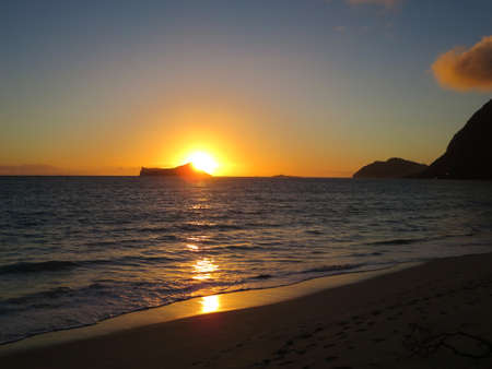 Early Morning Sunrise on Waimanalo Beach over Rabbit Island bursting over the island on Oahu, Hawaii.の写真素材