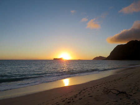 Early Morning Sunrise on Waimanalo Beach over Rabbit Island bursting over the island on Oahu, Hawaii.の写真素材