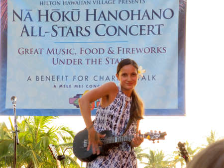 WAIKIKI, HI - MAY 10: Hawaiian style Musician Taimane Gardner plays Ukulele on stage at the Na Hoku Hanohaho All-Stars Concert as the sunset washes the light out around her on May 10, 2014 at the Hilton Hawaiian Village in Waikiki, Hawaii. のeditorial素材