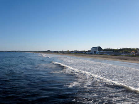Waves lap on Old Orchard Beach with new hotel and amusement park on Maine Coastline south of Portland.の写真素材