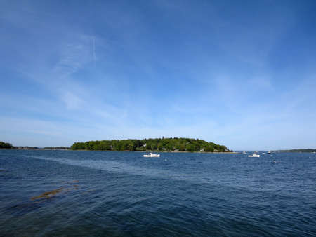 Boats in the water in front of Littlejohn Island, Yarmouth, Maine on a beautiful day.の写真素材