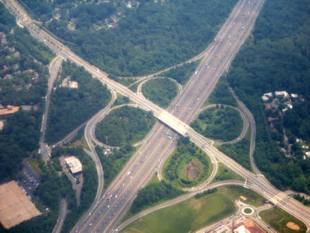 Highway clover leaf interchange circles in Washington DC area aerial surrounded by forest.        の写真素材