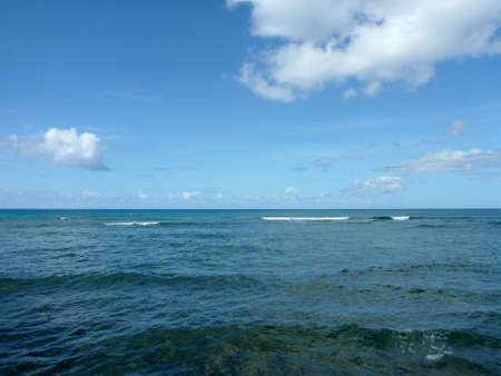 Shallow ocean waters with small waves breaking in the distance of Waikiki area looking into the pacific ocean.の写真素材