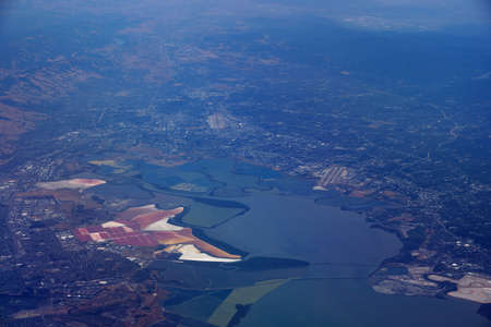 Aerial view of salt evaporation ponds, bridge, airports, cities surrounding San Francisco Bay near San Jose, California, United States.の写真素材
