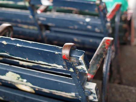 Old Baseball park seat with chipping blue paint with white and red layers underneath beginning to be revealed in Fenway park.の写真素材
