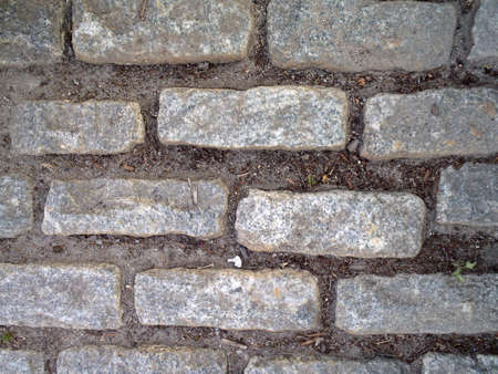 Looking down at Gray Cobble stone path with bits of dirt.の写真素材