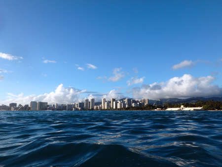 Historic Natatorium, Waikiki, Honolulu cityscape and San Souci Beach, coconut trees and lifeguard tower on a nice day Oahu, Hawaii seen from the water. の写真素材