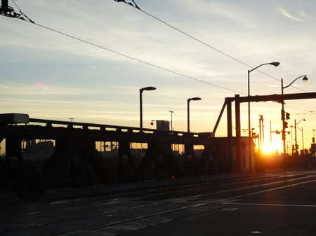 Sunset over historic 4th bridge with rail tracks in San Francisco.の写真素材