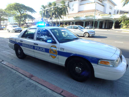 HONOLULU - AUGUST 20:  Honolulu Police Department police car lights flash on Ala Moana Boulevard across from mall on Oahu, Hawaii.  August 20, 2014.のeditorial素材