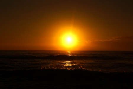 Spectacular Sunrise over the ocean with waves crashing along shore in Hana on Maui, Hawaii.の写真素材