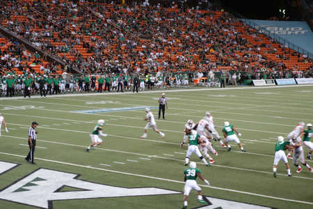HONOLULU - NOVEMBER 22: UNLV Football Runningback runs towards the end zone as other players scrabble for position during college game at Aloha Stadium in Honolulu, Hawaii on November 22, 2014.のeditorial素材