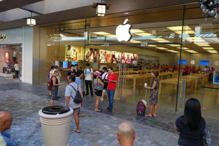 HONOLULU - December 12, 2014: Customers wait outside for The Apple retail store opening as employees prepare inside at the Honolulu Ala Moana Center store which sells the latest generation of the ipad, iphones, and ipods with a retina display, as people wのeditorial素材