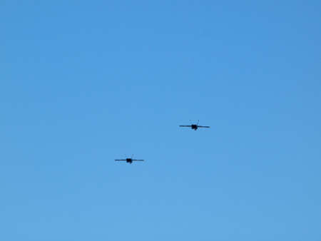 Two Fighter Jets fly in the air in a blue sky.の写真素材